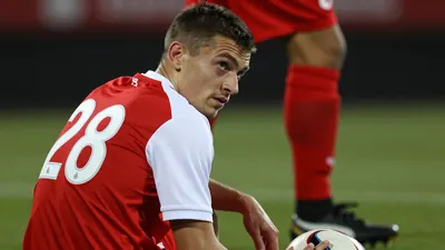A photorealistic image of an anonymous 28-year-old Dinamo player in a red and white jersey with a white number 28 on the...
