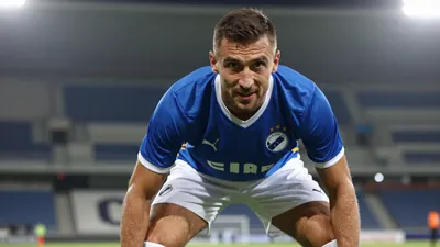 A photorealistic image of an anonymous Dinamo Zagreb player, aged 25-30, wearing a blue jersey with white shorts and...
