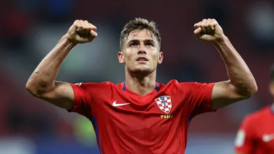 Photorealistic image of a 23-year-old Croatian striker in a red football kit, waist-up shot, celebrating with arms...
