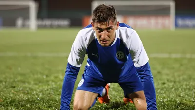 A determined, sweat-drenched, 28-year-old Dinamo midfielder in a plain blue and white training top, eyes locked intensely...