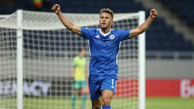 A photorealistic image of a muscular 25-year-old right-back in a blue jersey, celebrating a goal in extra time