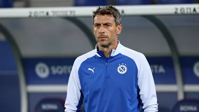 A 30-year-old, athletic build, Dinamo Zagreb coach, in a plain blue and white training top, stands pitchside at Stadion...