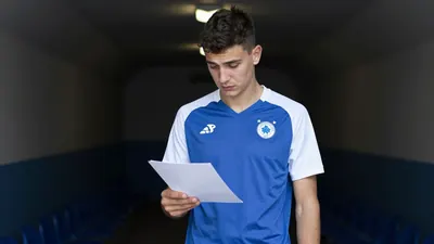 A 22-year-old, lean-built, blue-eyed, dark-haired Dinamo youth product, dressed in a plain, blue, and white, cotton...