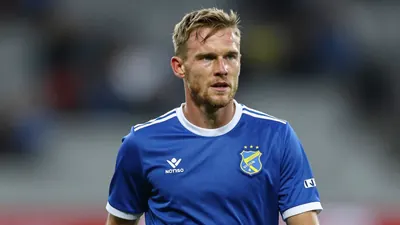A 30-year-old male football player, waist-up, wearing a blue jersey, in the midst of a match against Viking