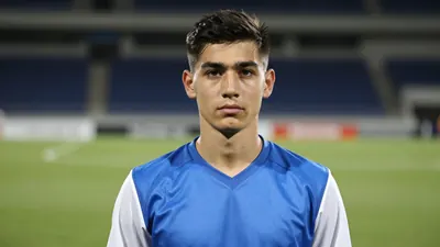 Young goalkeeper, mid-20s, athletic build, intense eyes, head-and-shoulders shot;
