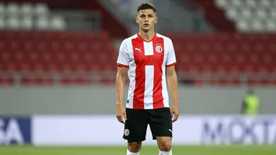 A 19-year-old, 1.80m tall, athletic-looking player with a short haircut, wearing a Dinamo Zagreb jersey with a white and...