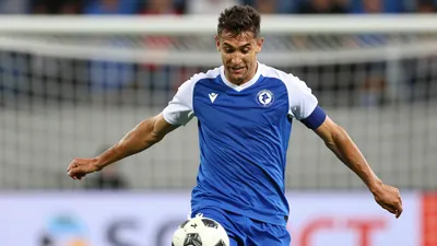 A photorealistic image of an anonymous Dinamo B player, wearing a blue jersey with white sleeves and a white collar, in a...