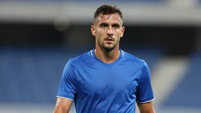 Mid-30s, muscular Dinamo Zagreb midfielder, head-and-shoulders, intense gaze, sweat-glazed skin, wearing plain unmarked...
