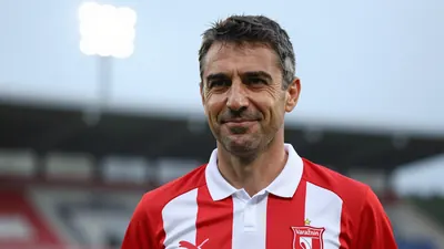 A 35-year-old Varaždin coach, wearing a red and white striped shirt with a white collar, looking confident with a slight...
