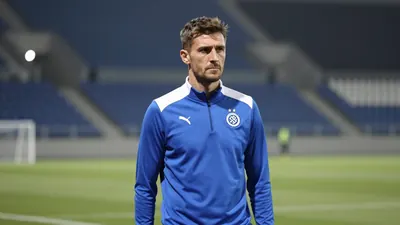 Medium shot of a 25-year-old, athletic, coach with a stern expression, wearing a GNK Dinamo Zagreb blue and white plain...